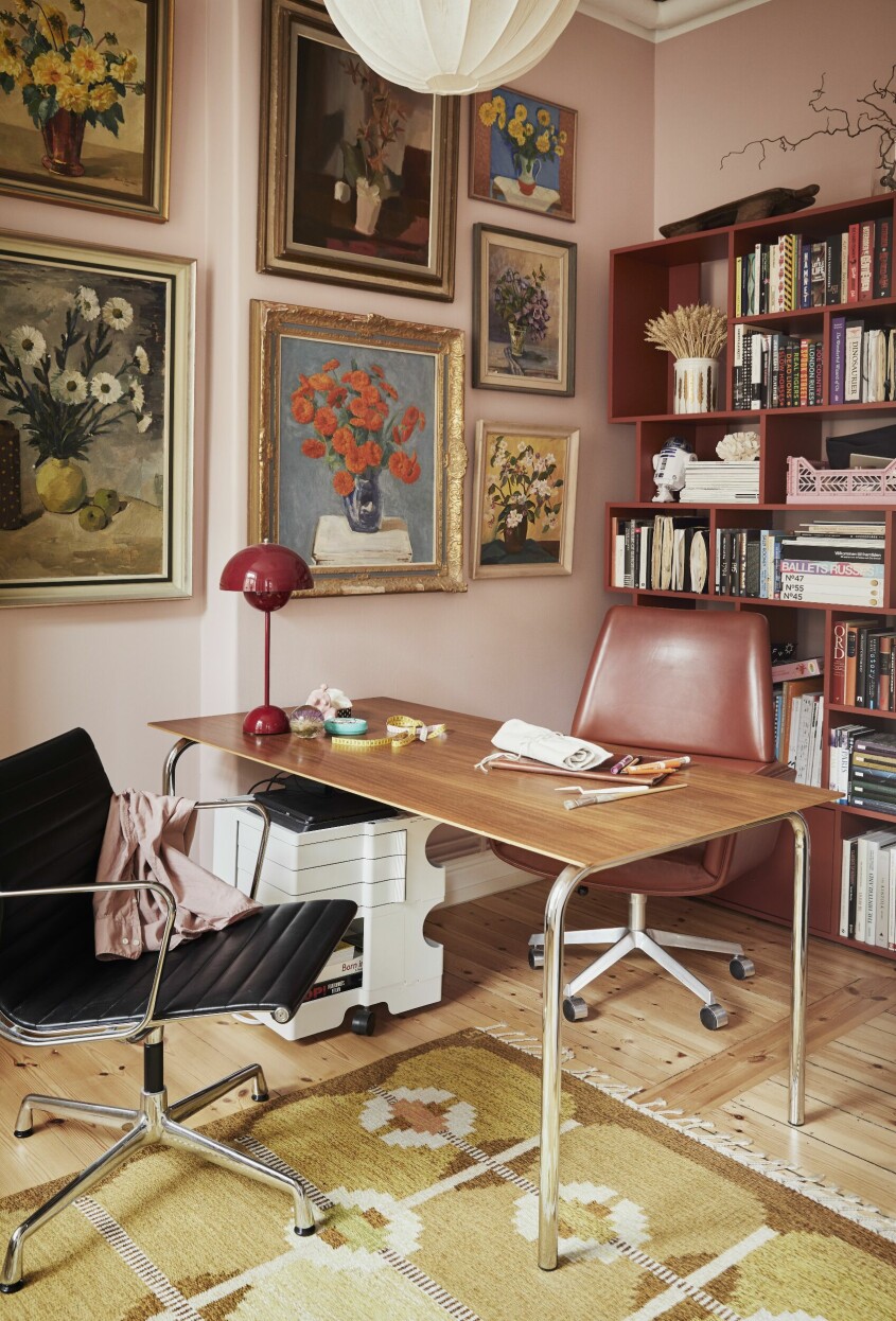 Den mjukrosa färgen på väggarna i arbetsrummet är specialblandad av Little Greene efter att Alina och Johannes testat en rad olika rosa varianter. På väggen sitter en samling av tavlor med blommotiv. Stolar, Eames och Finn Juhl, hylla Tylko och bordslampa från &Tradition. Arbetsrum inspiration