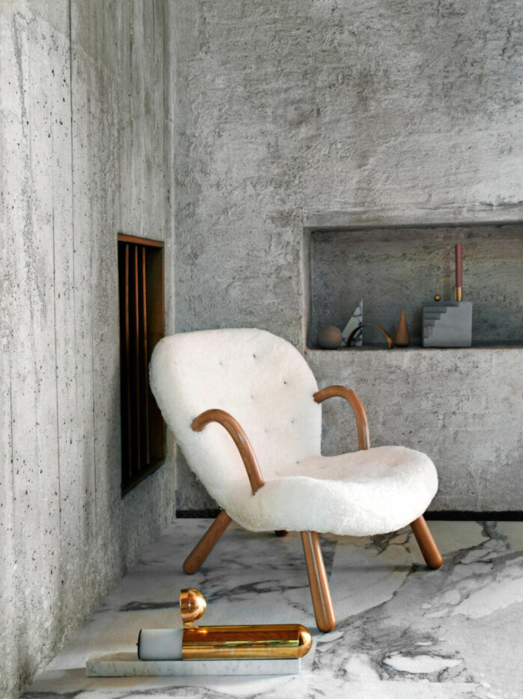 Matta <em>Sense of Marble</em>, Desso. Fåtölj <em>Arctander</em>, Paustian. Bordslampa <em>ISP</em>, DCW Editions. Skulptur, Kristina Dam. Ljusstake <em>Balance</em>, Ferm Living. Vit fåtölj Arctander från Paustian i grått rum