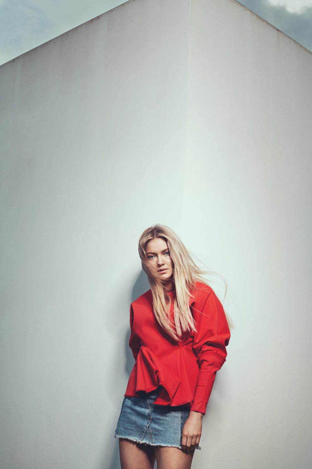 Astrid S i röd tröja och jeanskjol