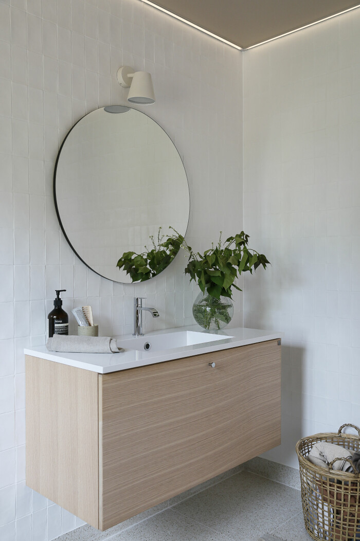 Vitpigmenterad ek hos Ballingslöv. Foto: Ballingslöv badrum med kommod i ljust trä och vita kaklade väggar från ballingslöv