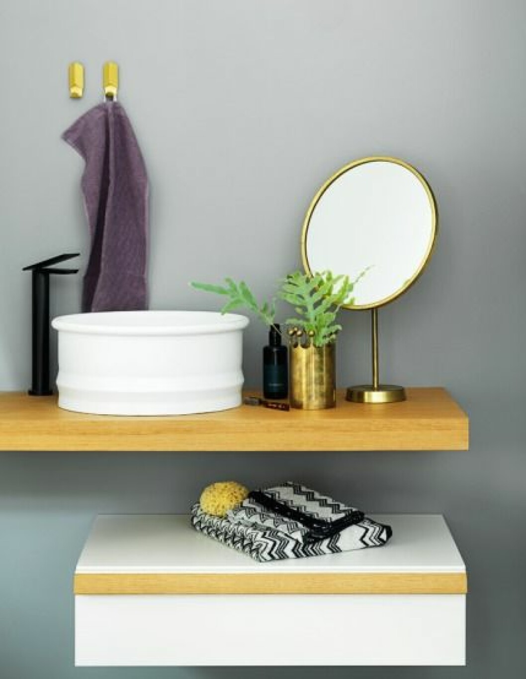 Väggfast och svävande – Tvättställ Viegues, diameter 43,5 cm, på topp i teak Flat XL, 38 400 kr, tvättställsblandare Sen, höjd 29,5 cm, 9 250 kr, och vägghängd låda Flat XL, 80x40x20 cm, 13 605 kr, allt från Planoform. Vintagespegel i mässing från Svenskt Tenn, 7 500 kr, och kronvas i mässing, design Pierre Forsell, 5 000 kr, Nordlings Antik. Krokar Volet, 199 kr, Hay/Gulled. Gästhandduk Lina, 89 kr, Himla. Svartvit frottéhandduk, 155 kr, och badlakan, 350 kr, Missoni/Länna Möbler. badrumsinredning