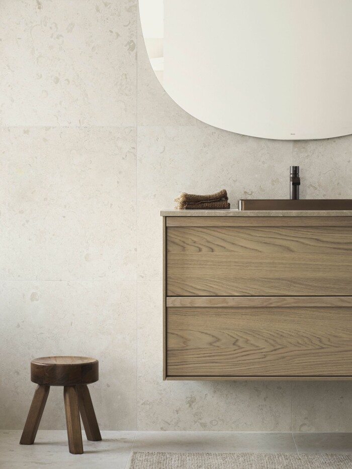 Beige och grått är tidlösa favoriter i badrumsinredningarna. På vägg och golv på bilden syns <em>Norrvange Ivory </em>från Bricmate. Foto: Bricmate beige badrum med detaljer i trä