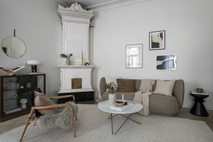 Beige inredning och kakelugn i Angelica Blicks vardagsrum