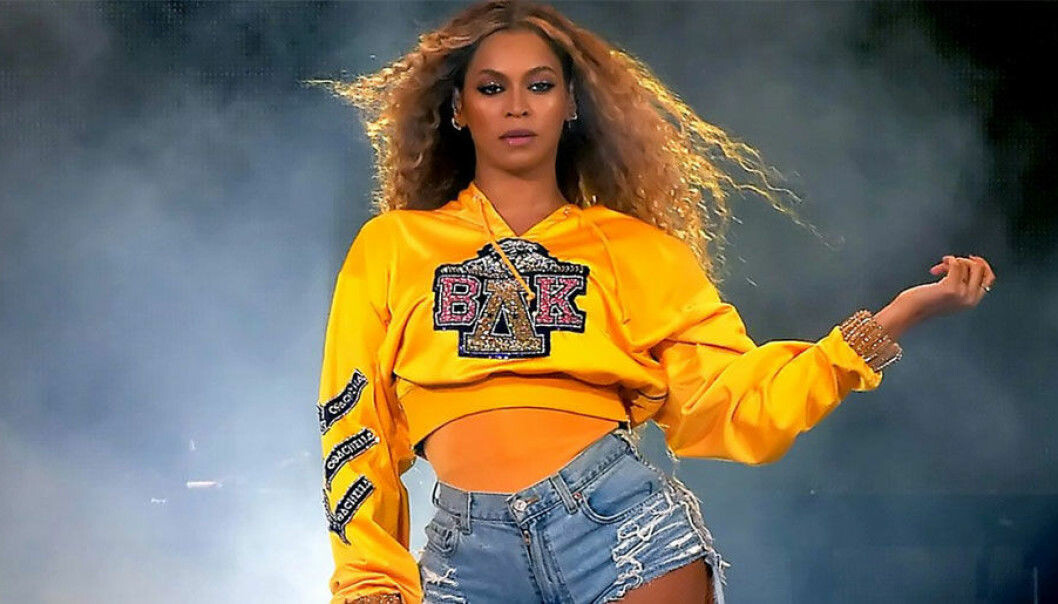 Beyoncé i gul tröja och jeansshorts