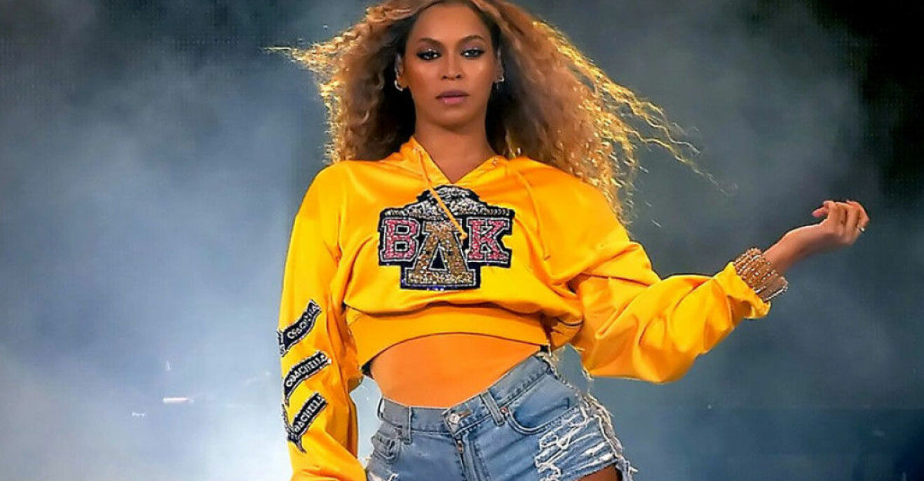 Beyoncé i gul tröja och jeansshorts