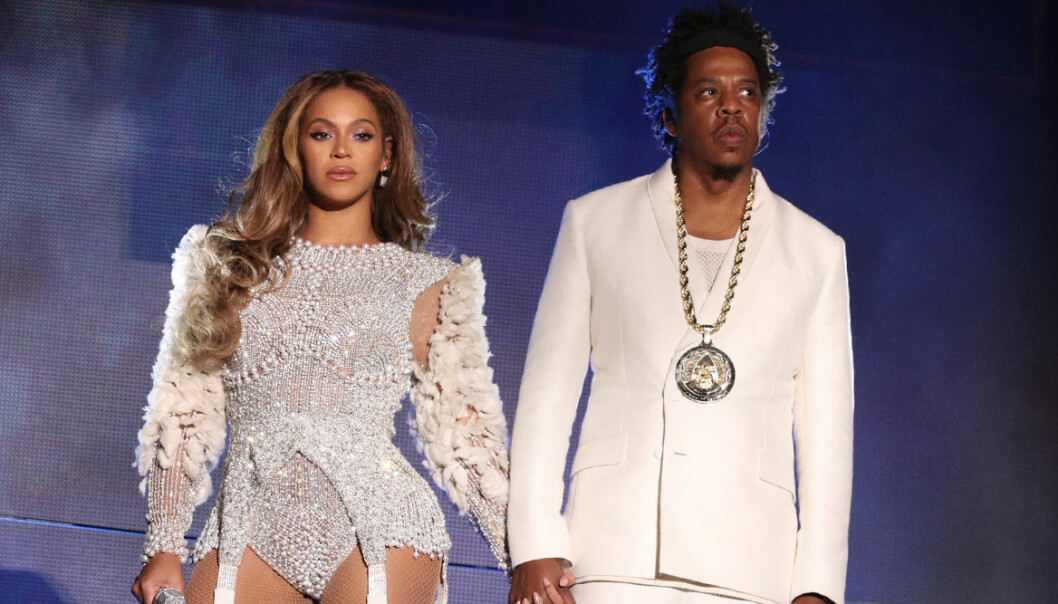 Beyonce och Jay-z i vitt håller varandra i hand
