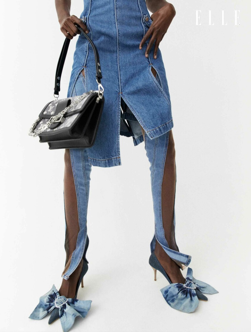 Klänning, 8 167 kr, JW Anderson/Mytheresa. Jeans, 7 514 kr, Mugler/Mytheresa. Väska, 37 000 kr, Louis Vuitton. Skor, 1 960 kr, Merrfer. Fotomodellen bär en klänning i denim tillsammans med en svart handväska och skor med denimrosetter.