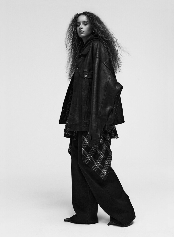 Jacka, 40 635 kr, hoodie, 7 245 kr, skjorta, 7 800 kr, jeans, 8 850 kr, skor, 15 100 kr, och örhänge, 3 075 kr, allt Balenciaga. Modellen har på sig en oversize jacka, hoodie, rutig skjorta och jeans, allt från Balenciaga