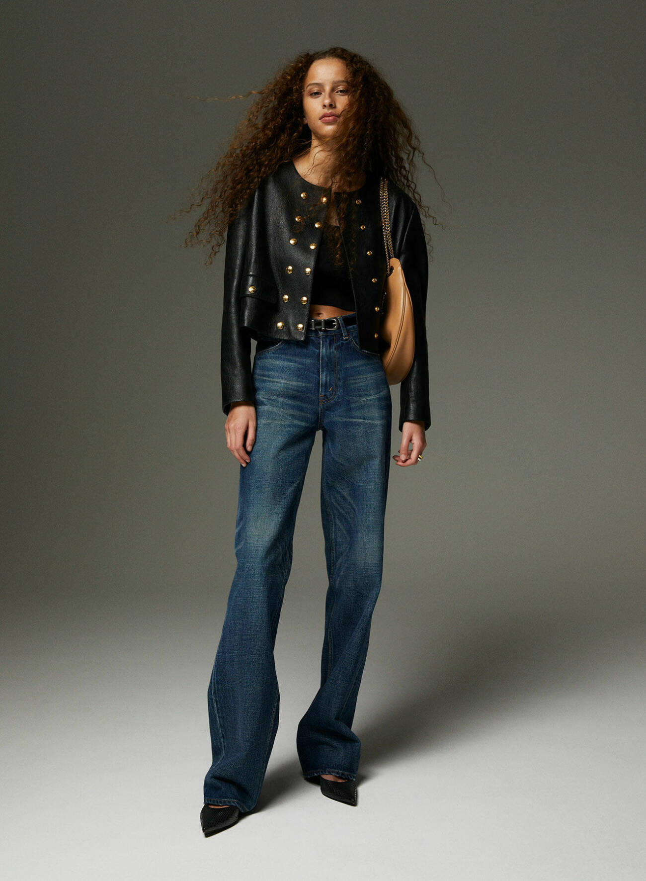 Modellen har på sig svart jacka och topp, mörkblå jeans och svarta skor, allt från Celine by Hedi Slimane