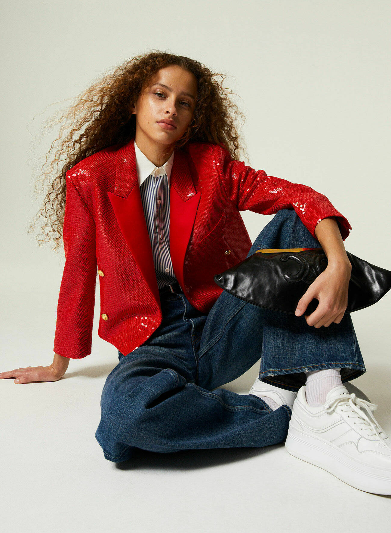 Modellen Dyanira har på sig en röd kavaj med paljetter, mörkblå jeans och vita sneakers, allt från Celine by Hedi Slimane