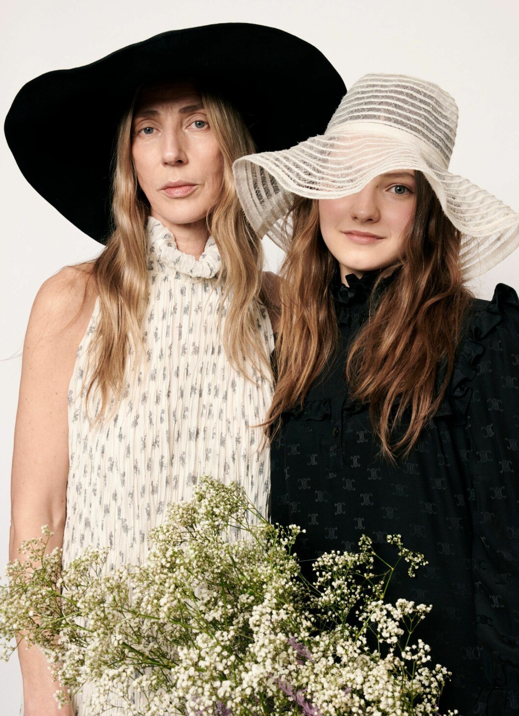 Britta: Klänning, 31 575 kr, Chloé. Hatt, vintage. Ingrid: Klänning, 19 535 kr, Celine by Hedi Slimane. Hatt, vintage. Britta i mönstrad klänning från Chloé