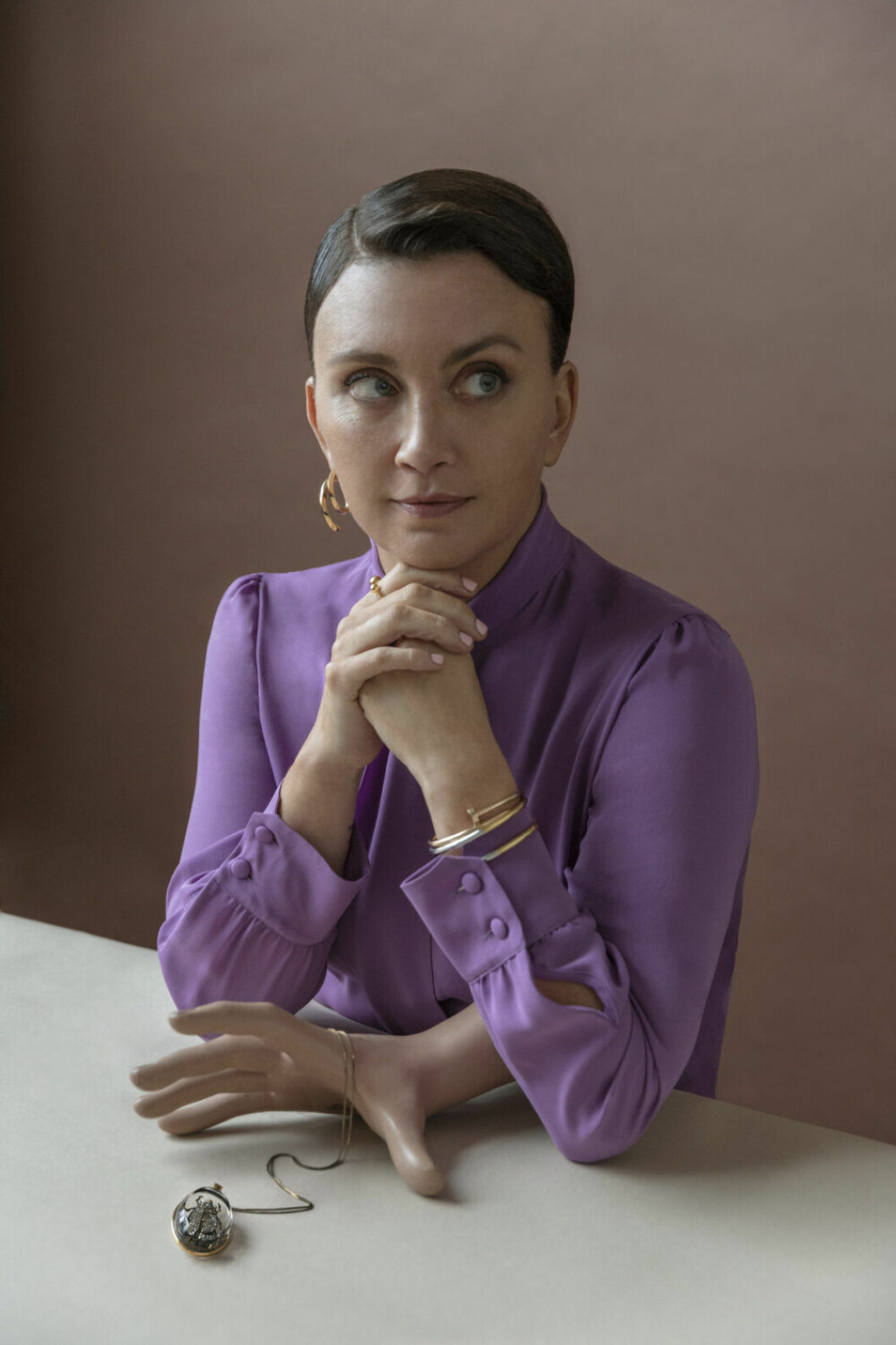 Blus, Gucci. Örhänge, Acne Studios. Armband i form spik, Cartier. Stelt armband och ring, båda Sophie by Sophie/NK Access. Halsband, Alexander McQueen/NK Access. Camilla Läckberg i lila blus från Gucci