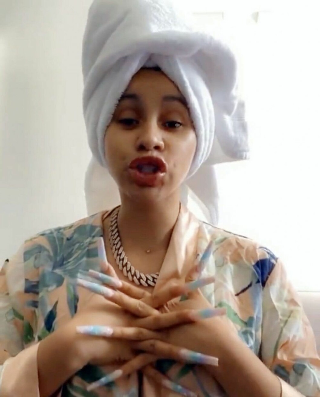Cardi B utan smink med handduk på huvudet