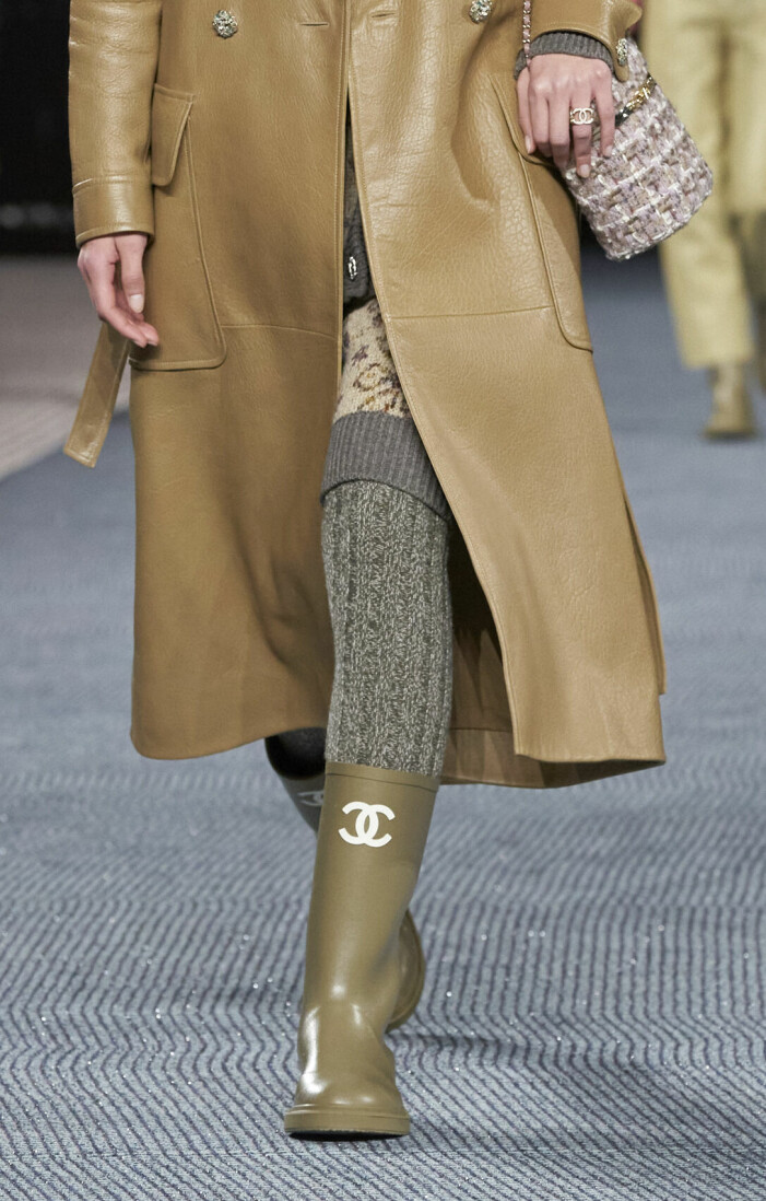 Gummistövlar med söta cc-loggor syntes på catwalken hos Chanel AW22. Gummistövlar i beige med cc-logga från Chanel.