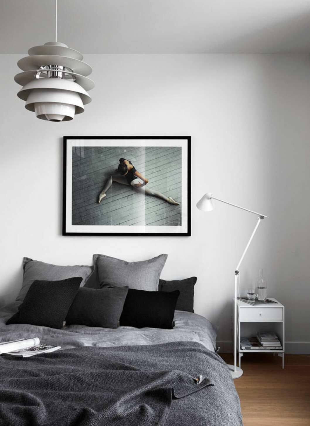 Avskalat och stillsamt i sovrummet. Fotokonst Ballerina av Max Modén. Sänglinne och stickade plädar från Georg Jensen Damask. Lampor från Louis Poulsen och sängbord från Montana.