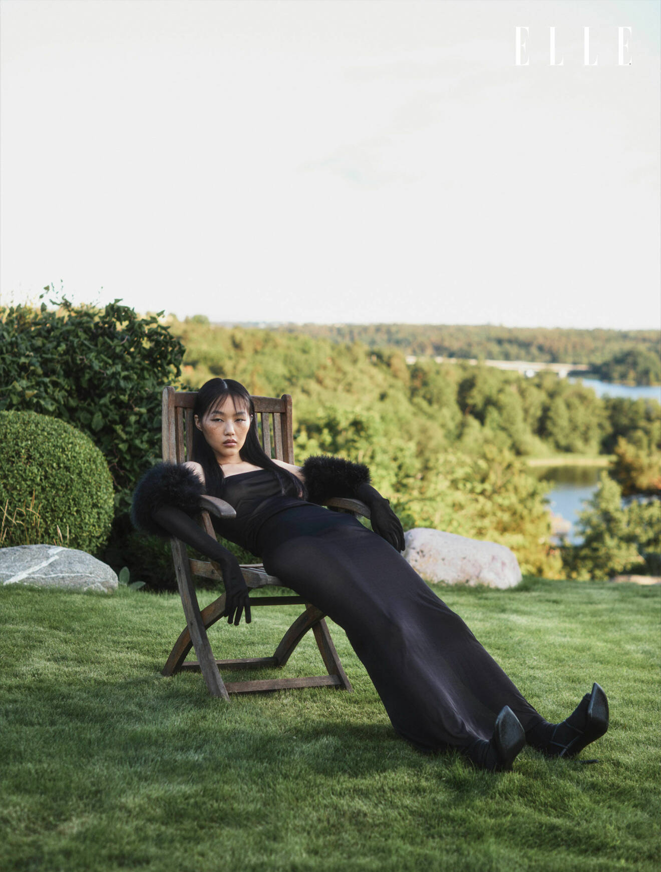 Modellen har på sig en svart långklänning och svarta handskar med fjädrar, allt från Saint Laurent by Anthony Vaccarello