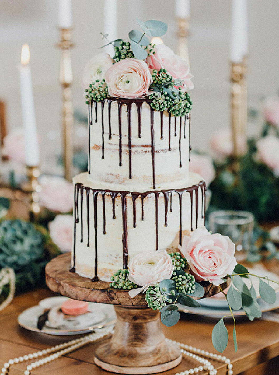 Foto: <a href="http://www.hochzeitswahn.de/inspirationsideen/glamouroese-nostalgie-mit-rosa-romantik/?crlt.pid=camp.H8zyaImMVf73" target="_blank" rel="noopener">Hochzeitswahn.de</a> Tårtan får en romantisk touch med hjälp av rosor och mörk choklad.