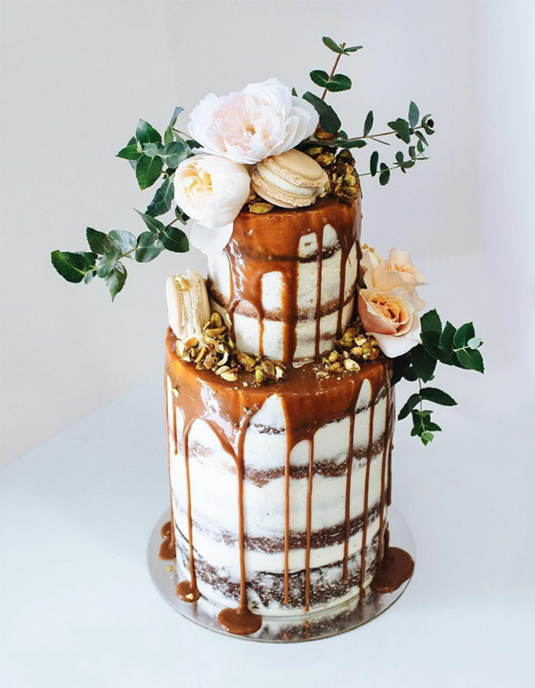 Foto: Instagram/<a href="https://www.instagram.com/tome____/" target="_blank" rel="noopener">@tome____</a> via <a href="https://nouba.com.au/best-creative-wedding-cakes-bakers-australia-new-zealand" target="_blank" rel="noopener">nouba.com.au</a> Bröllopstårta med rinnande kolasås och topping.