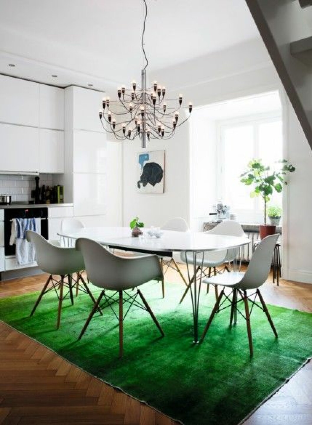 I köket en trappa ner: Superellips-bordet var ett fynd på Blocket. Köksstolar DSW och DAW, design Charles och Ray Eames. Ljuskrona 2097/30, design Gino Sarfatti för Flos. Matta köpt på Nessims. Eames-stolar-köksbord-superellipsbordet-lampa-209730-design-gino-sarfatti-flos-grön-matta-nessim-fikonträd-espressomaskin