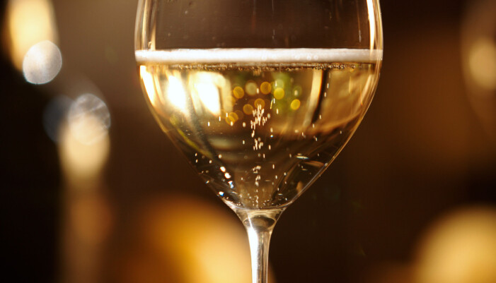 Vitvinsglas med mousserande vin i glaset.
