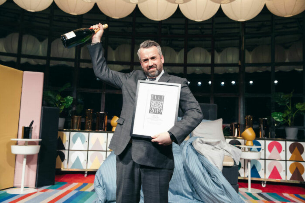 Glad vinnare med champagneflaska på ELLE Decoration Swedish Design Awards 2019