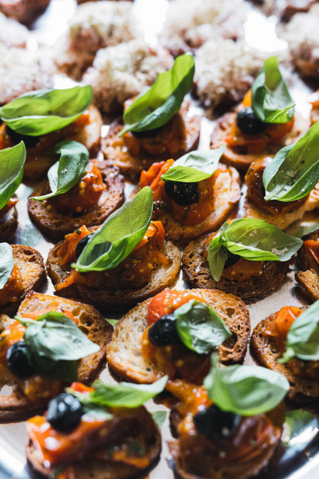 Crostinis med bakade svenska tomater med svart vitlök och basilika (vegansk). Crostinis med bakade svenska tomater med svart vitlök och basilika (vegansk).