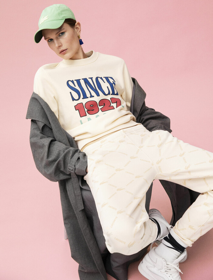 Trenchcoat, 11 500 kr, BITE Studios. Tröja, 1 500 kr, byxor, 1 500 kr, och keps, 700 kr, allt Lacoste. Strumpor, 125 kr, Adidas. Skor,7 500 kr, Celine by Hedi Slimane. Örhänge,4 003 kr, Balenciaga. Modellen har på sig trenchcoat från BITE Studios, tröja, byxor och keps från Lacoste, strumpor från Adidas, skor från Celine by Hedi Slimane, örhänge från Balenciaga.