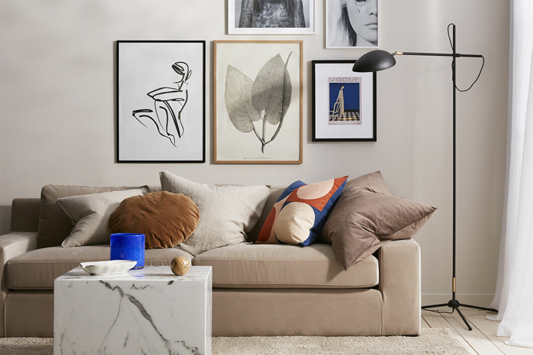 Ge den sobra skandinaviska stilen ett färglyft med abstrakta tavlor i svartvitt och färggranna accessoarer. Beige soffa från Ellos Home och posters samt koboltblå kruka