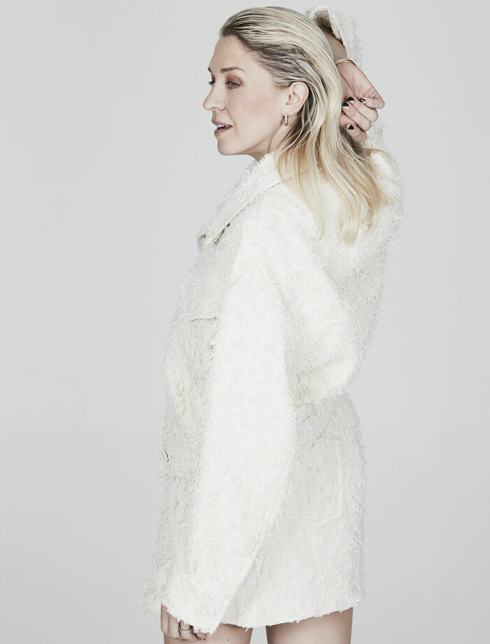 Emilia i jacka och kjol från Acne Studios. Örhängen, Nathalie Schuterman. Emilia de Poret i vit jacka och vit kjol.
