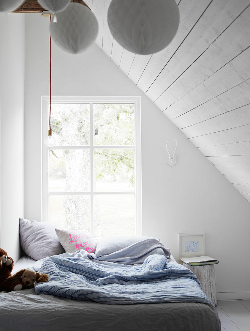 Dottern Ellas rum. Lampa Lucky från Flux. Vitmålad stubbe från skogen. Vita pappersbollar från Ikea. enkarlekshistoria_sovrum
