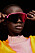 Modellen bär en stickad tröja i rosa och gult från Acne Studios och rosa solglasögon från Oakley