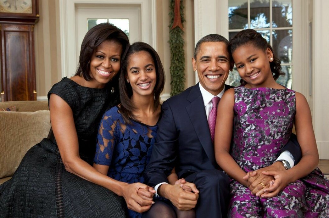 Michelle, Malia, Barack och Sasha Obama. sitter i en soffa finklädda och ler.