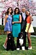 Michelle, Malia, Barack och Sasha Obama. står i trädgården i färgglada kläder och med två hundar framför sig