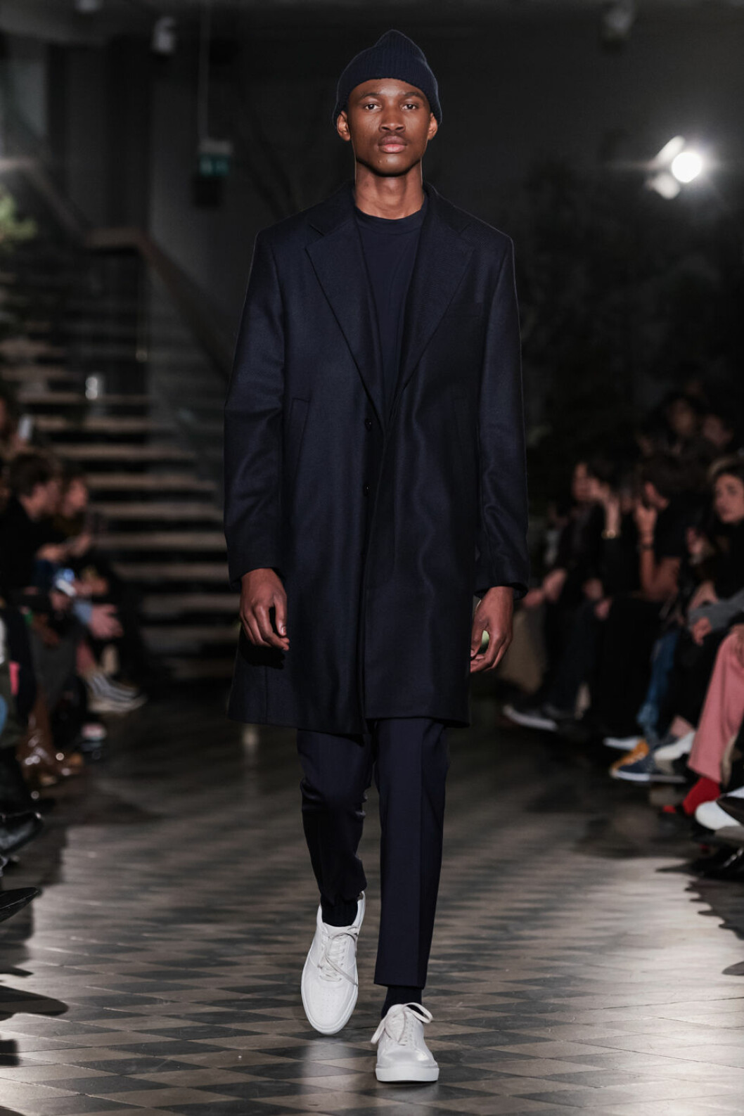 Filippa K AW 18, man i mössa och kappa.