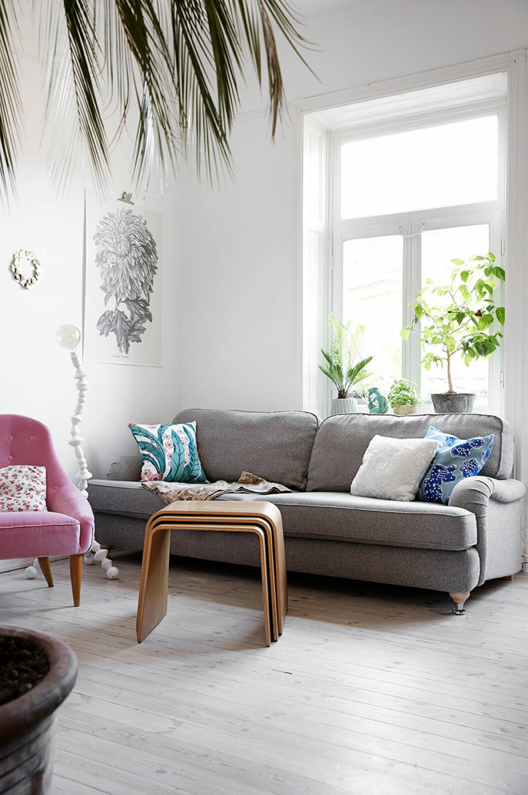 Grå soffa och ljusrosa fåtölj i vardagsrummet