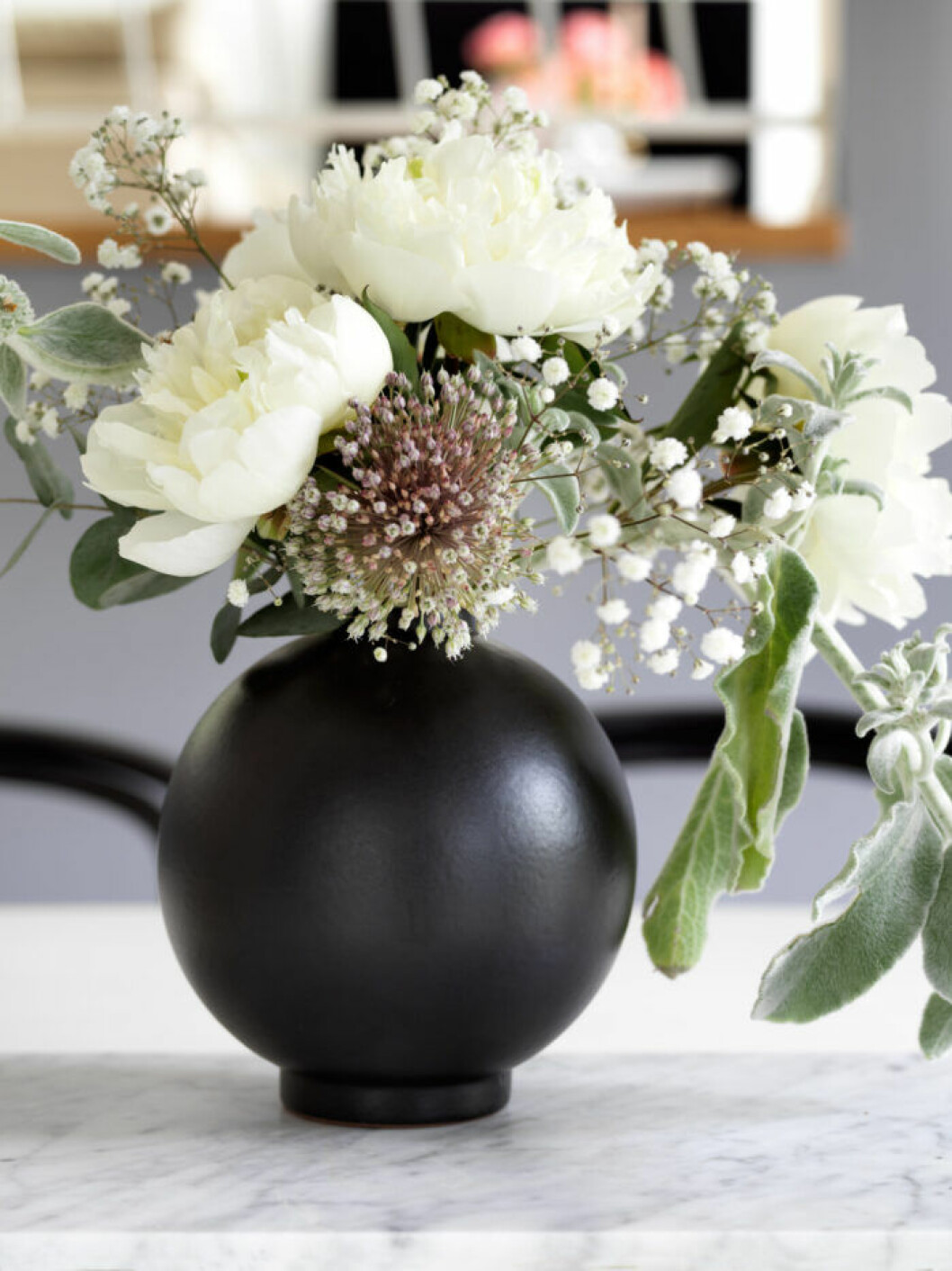 Svart vas med säsongens blommor hos Frida Fahrman