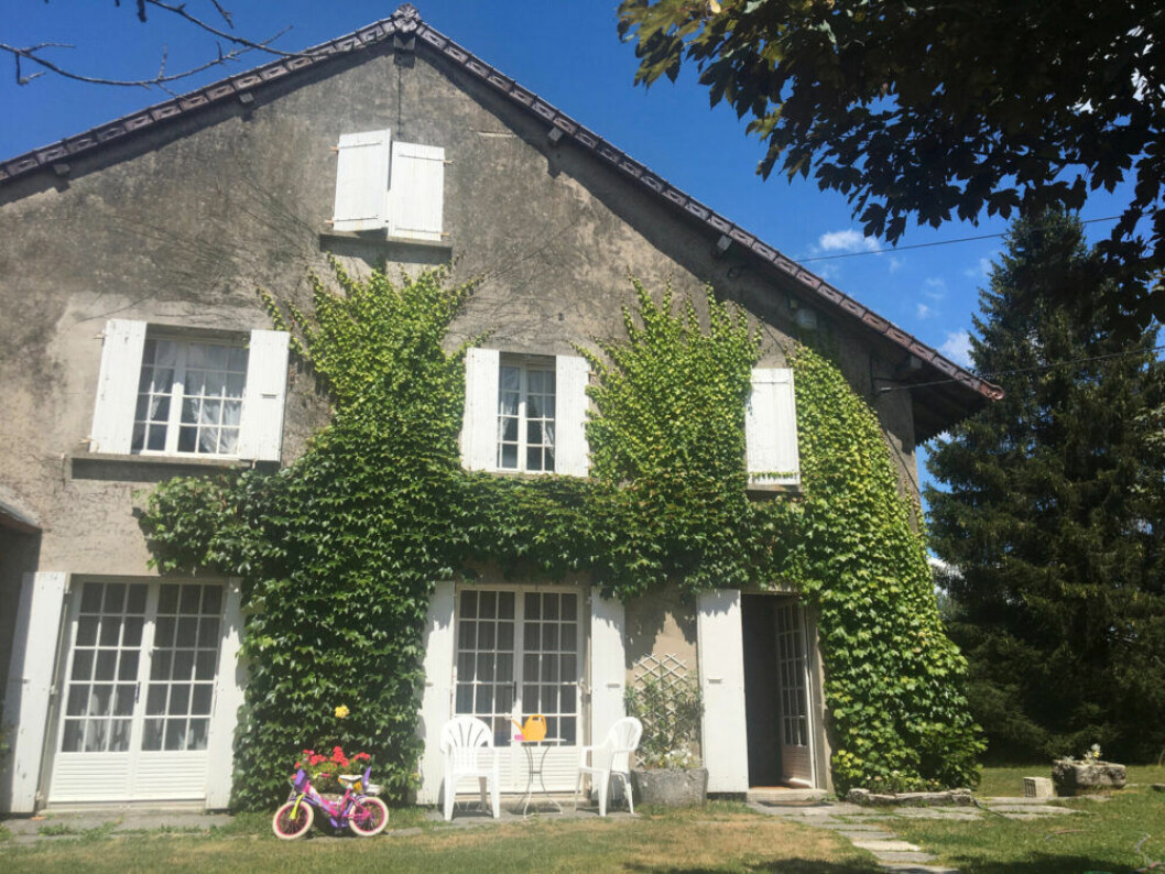 Släkthuset i Jura, Frankrike. Grått hus med murgröna i franska Jura