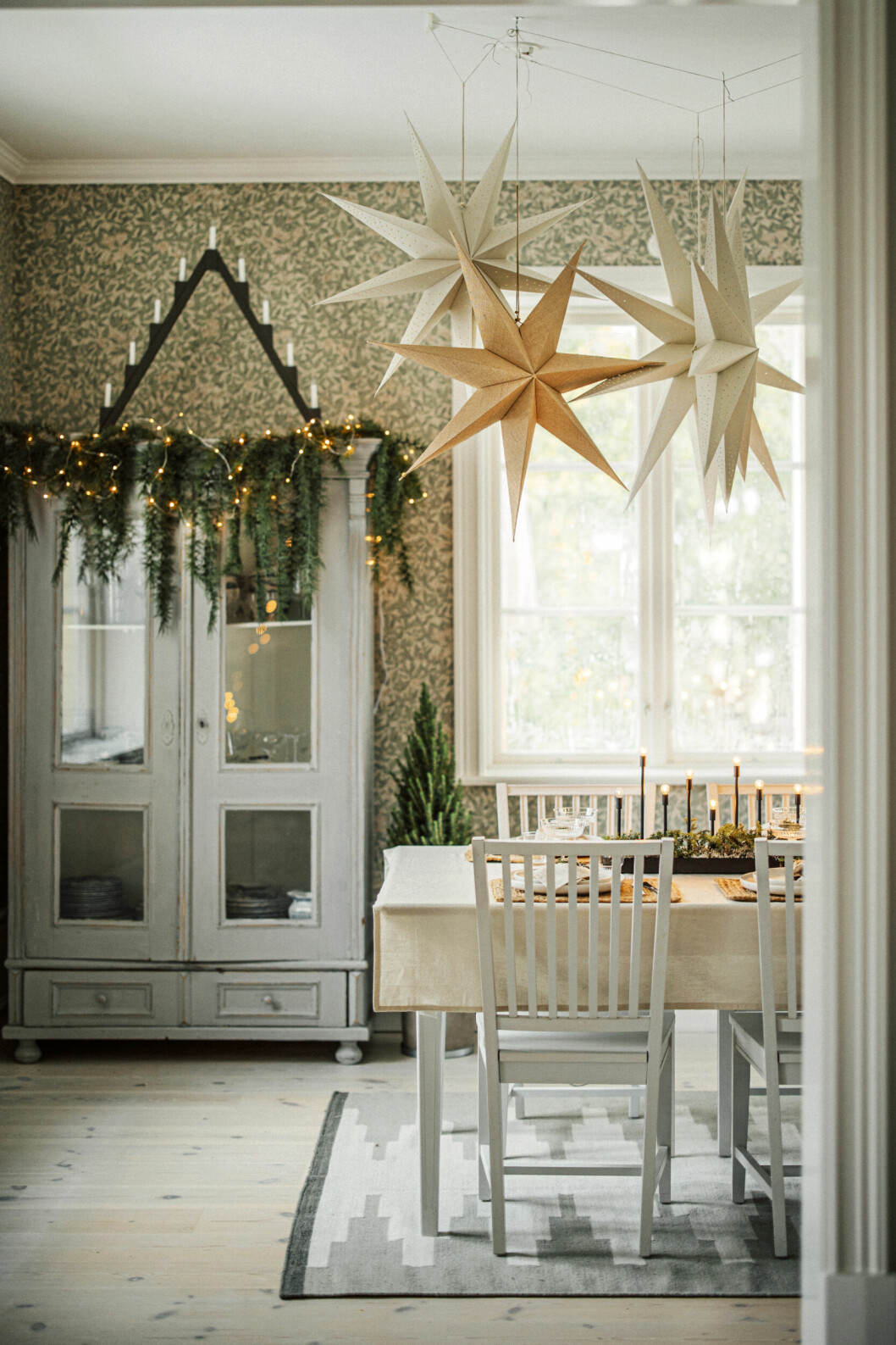 Att hänga flera adventsstjärnor i grupp är en annorlunda och rolig idé till juldekorationerna. adventsstjärnor i grupp ovanför matbord
