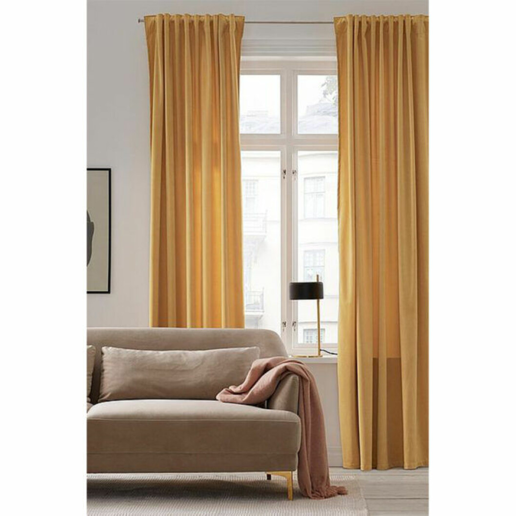 Gula gardiner med mjukt fall från Ellos Home. <a href="http://www.awin1.com/cread.php?awinaffid=439039&awinmid=8905&clickref=gardiner&p=https%3A%2F%2Fwww.ellos.se%2Fellos-home%2Fveckbandslangd-daisy-i-sammet-2-pack-med-kombiband%2F1044015-14" target="_blank" rel="noopener">Här kan du läsa mer och köpa dem</a>. Gula och färgglada gardiner