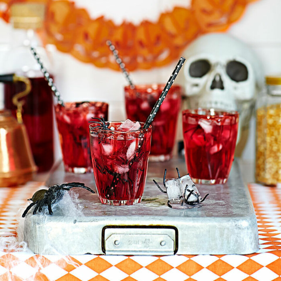 Blodröd lemonad med spindel-isbitar. Blodröd alkoholfri lemonad för Halloween