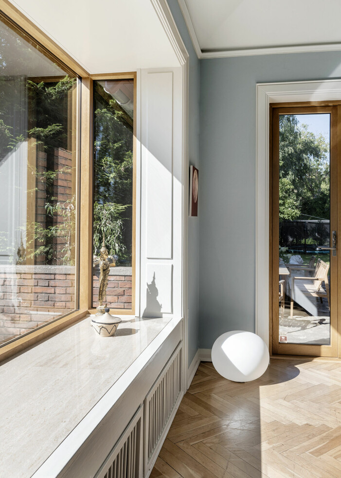 Kirstine sitter i en Shell chair av Hans J. Wegner. Sidobordet är tillverkat av återvunnen plast, Wild Studio. Huset är på nästan 400 kvadratmeter med gott om plats för både familj, hundar och umgänge.