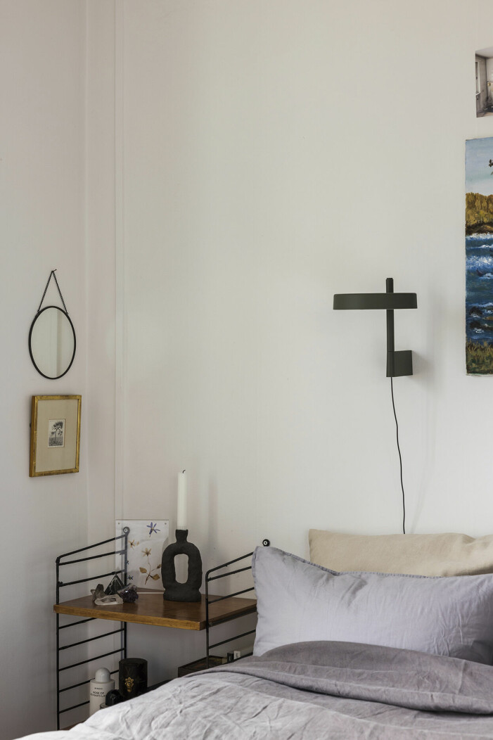 Tavlan med eken är en gåva. De pressade blommorna har Nina och Sigrid plockat. Lampan <em>Pastille</em> i favoritfärgen mörkgrön, Wästberg. Nina Ojas lilla sovrum är mysigt inrett med konst och en lampa i favoritfärgen mörkgrön