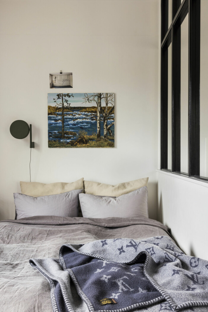 Ninas favoritplats på jorden Kengisforsen målad av mormor Märta Muotka. Lampa <em>Pastille</em>, Wästberg. Sängkläder, Midnatt. Överkastet ett underlakan från PelleVävare. Filt, Louis Vuitton. Ovanför sängen har Nina en tavla som föreställer Kengisforsen, målad av hennes mormor Märta Muotka