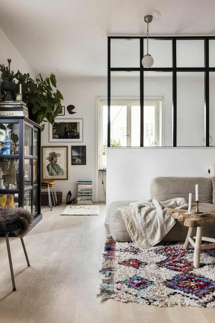 Väggen som skiljer vardagsrum från sovrum har en snickare byggt efter Ninas ritning. Filt, & Tradition. Svart skåp, Ikea. Väggen delar av vardagsrummet och ger Nina ett eget krypin