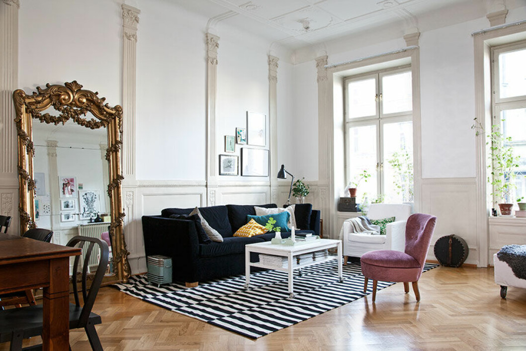 Spegeln är ärvd från Kristoffers familj. Den rosa fåtöljen är ett loppisfynd som klätts om. Soffa, matta och vit fåtölj från Ikea, Kuddar från Afroart, Svenskt Tenn och Numero 74. Mellan fönstren står en trumlåda, Kristoffer spelar trummor i bandet Pixie Carnation. hemmahos_vardagsrum