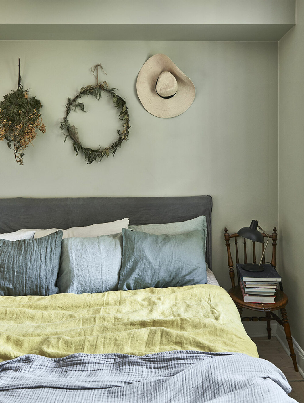 En krans och en solhatt på väggen ger sommarkänsla i inredningen. Foto: James Stokes Styling: Maria Nordin Syns i: <a href="https://www.elle.se/decoration/bohemiskt-och-naturnara-hemma-hos-sofia-wood/" target="_blank" rel="noopener">Bohemiskt och naturnära hemma hos Sofia Wood</a> Somrigt sovrum i grönt med kransar