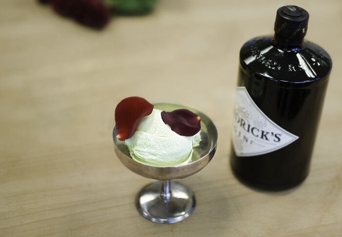 Glass med rosenblad och en flaska gin