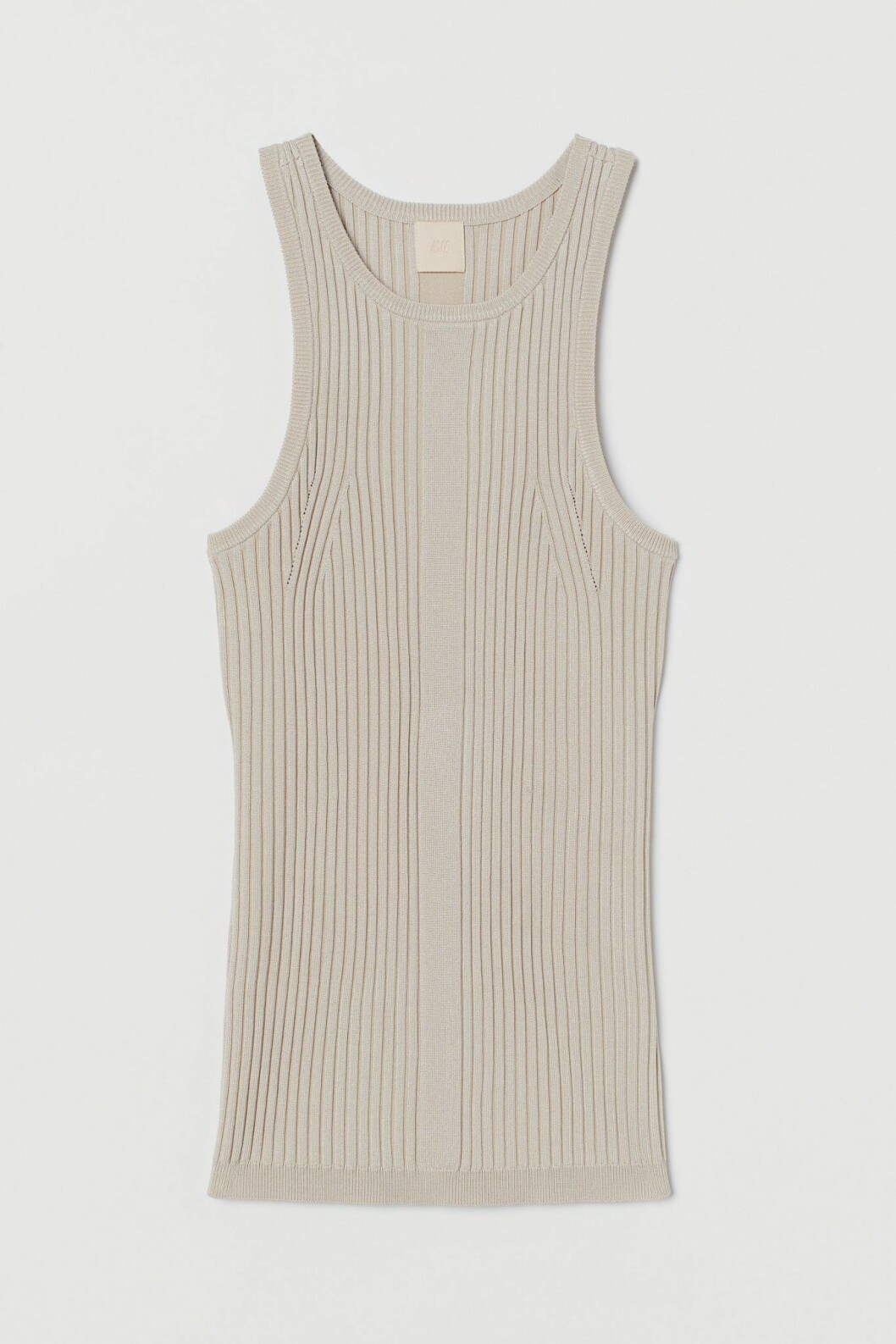 Bär ett ribb-stickat linne med hög hals under kavajen för en stilren look. Linne i beige från H&M.