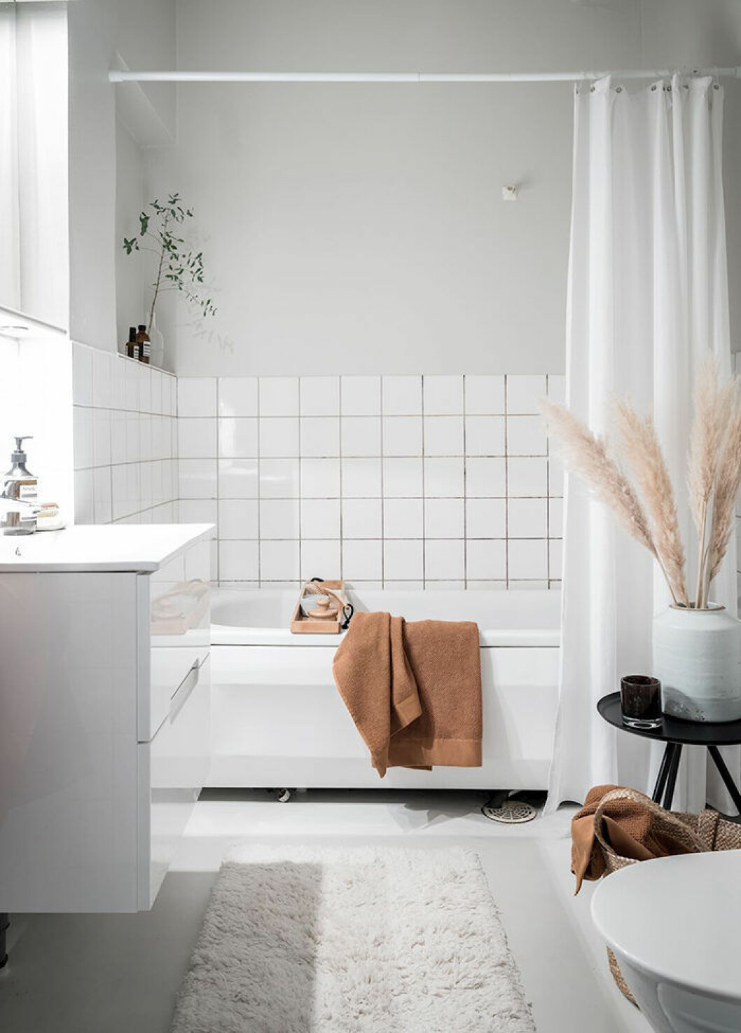 Hotellkänsla med mjuk matta och vackra detaljer. Foto: Alen Cordic Styling: By Bon för <a href="https://www.instagram.com/bjurfors_goteborg/?hl=sv" target="_blank" rel="noopener">Bjurfors</a>/mäklare: Jonas Rutberg Hotellkänsla i badrummet med matta och växter