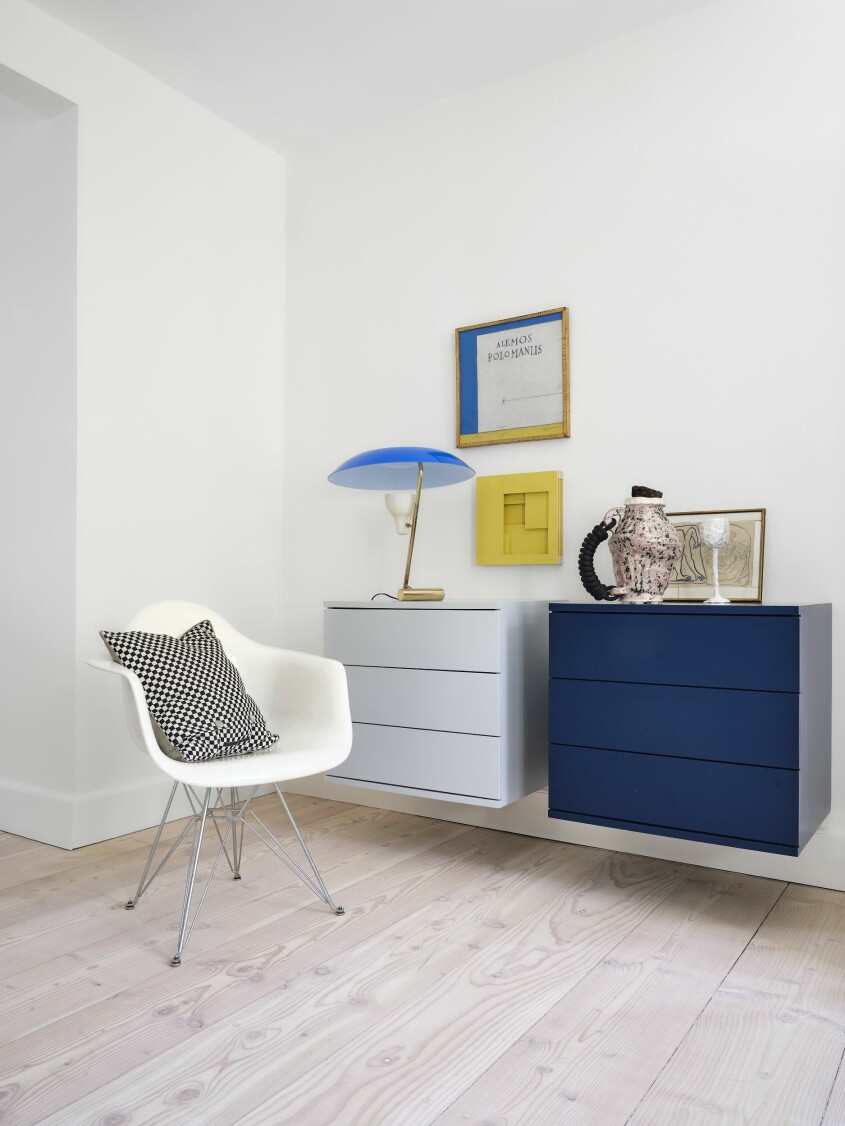 Byråerna är designade av Helles man Lars Oxfeldt Mortensen. Den klarblå lampan är Gino Sarfattis modell <span class=" italic" data-lab-italic_desktop="italic">548</span> och kommer från Asteps. Kannan är av Karl Monies, från Etage Projects. Karmstol av Eames för Vitra. Kudde, Helle Høgsbro Krag. Målning, <span class=" italic" data-lab-italic_desktop="italic">Grækeren</span> av Sven Dalsgaard. Den gula reliefen är av Kristine Engelbrecht. Byråer